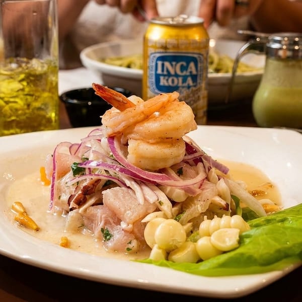 Peruvian ceviche with shrimp, fish, red onion, and corn, served with Inca Kola.